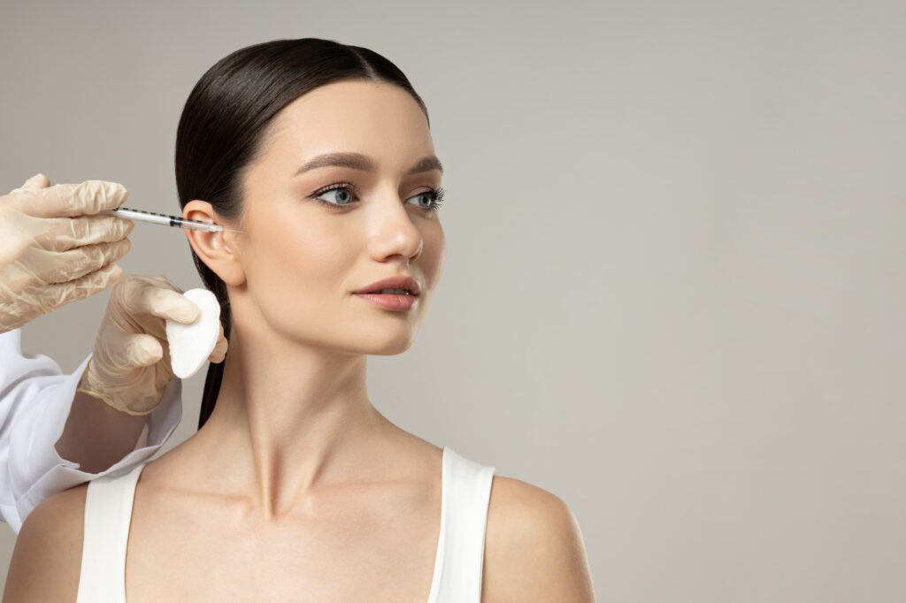 Médica aplicando tratamiento facial inyectable